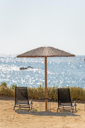 two chairs and an umbrella on the beach at Sandoa Residence - Lualaba & Tenke in Minia