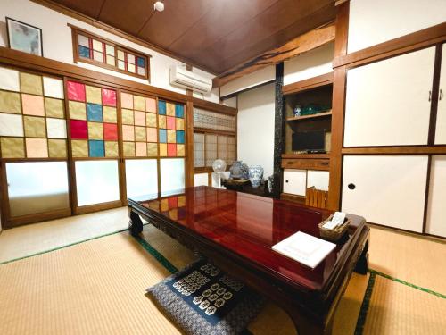 a room with a table and some stained glass windows at Guesthouse ＆ Beach Cafe Fuego in Hyuga