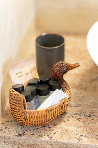 a basket with a cup and a duck on a counter at Sandoa Residence - Lualaba & Tenke in Minia