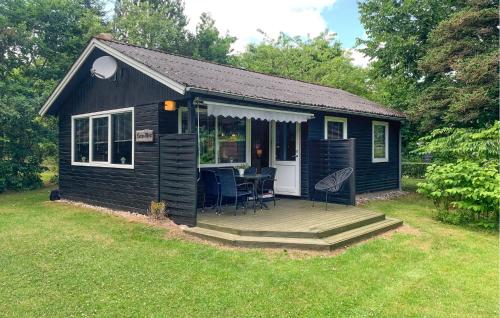 a small black shed with a deck and a table at 2 Bedroom Lovely Home In Silkeborg in Silkeborg