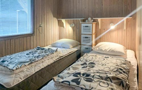 two beds are in a room with wooden walls at 2 Bedroom Lovely Home In Silkeborg in Silkeborg