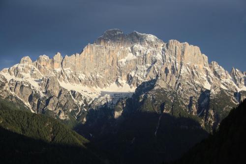 a large rocky mountain with snow on it at La Baita in Livinallongo del Col di Lana