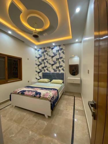 a bedroom with a bed and a ceiling at Johar Guesthouse-Suite 3Bed and Lounge in Karachi in Karachi