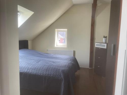 a bedroom with a blue bed and a window at Apartament an der Landgestüt in Warendorf