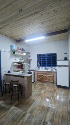 a large kitchen with a table and a counter at Rancho Vô de Ochinho in Sapucaí-Mirim