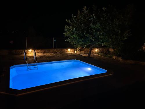 a swimming pool lit up at night at Old stone villa in Apokoronas Villa Nostalgia Kreta in Fílippos