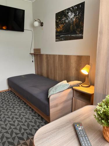a bedroom with a bed and a tv on the wall at 4 Pory Roku - Węgierska Górka in Węgierska Górka