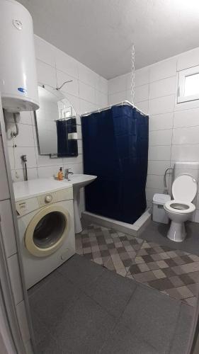 a bathroom with a washing machine and a toilet at SKOPJE Apartment in Skopje