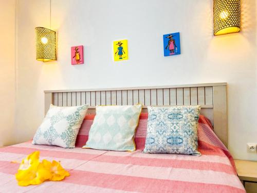 a bedroom with a bed with colorful pillows at Lakaz Kreol 2 Soupir Tourist Residence in Port Mathurin