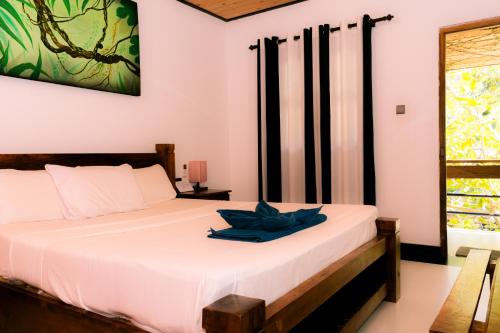 a bedroom with a bed with a blue towel on it at Eco Hotel Black & White - Anuradhapura in Mihintale