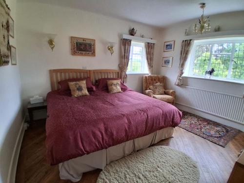 a bedroom with a bed and a chair and a window at Thornley House in Hexham