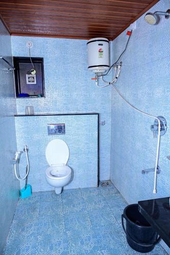 a bathroom with a toilet and a bucket on the wall at Coorg mansion in Madikeri