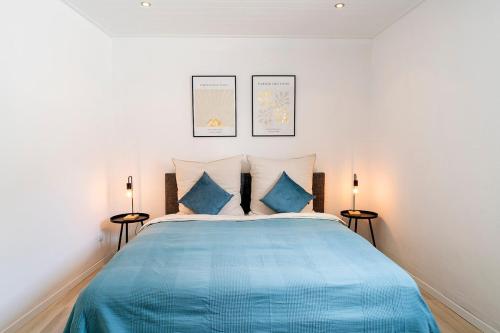 a bedroom with a bed with blue sheets and two lamps at Deluxe Koblenz Flat, Parken, Netflix, Ruhig in Bendorf