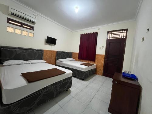 Postel nebo postele na pokoji v ubytování Hotel Sinar Rahayu 2