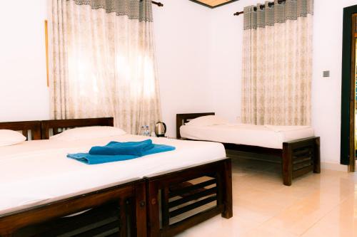 a room with two beds and a window at Eco Hotel Black & White - Anuradhapura in Mihintale