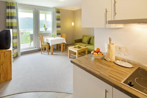 a kitchen and a living room with a table at PlusNaturHotel direkt am Ederseeufer Waldhotel Wiesemann und Ferienapartments in Waldeck