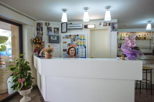 una donna in piedi dietro il bancone di un ristorante di Hotel Diamante 5 minuti dalla fiera di rimini CON PARCHEGGIO INCLUSO a Rimini