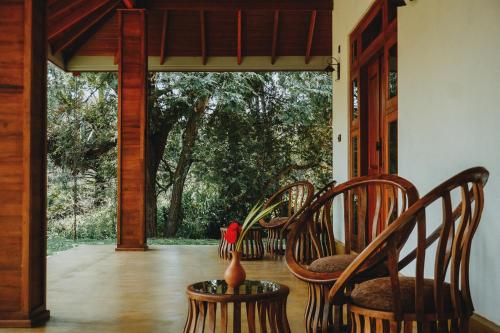 a porch with chairs and a vase on a table at The Coconut Experience Eco Lodge Wilpattu 