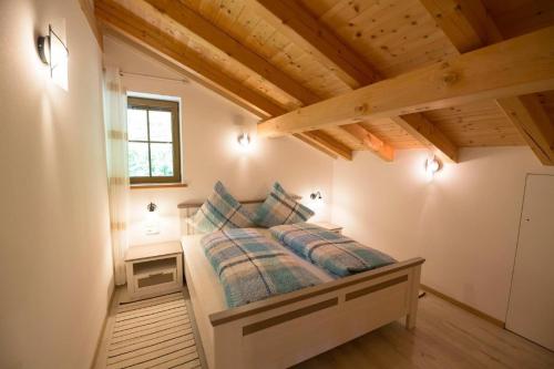 a bedroom with a bed in a room with wooden ceilings at Tscharfhof in San Leonardo in Passiria