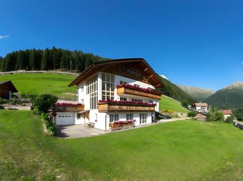 un edificio en una colina con un campo verde en Tscharfhof, en San Leonardo in Passiria