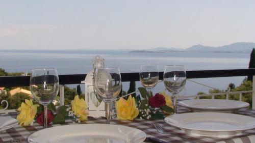 a table with glasses and plates on a table with a view at Apartment Zeus with private pool and sea view in Nisakion