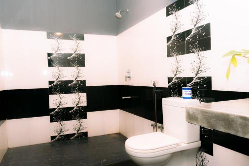 a black and white bathroom with a toilet and a sink at Eco Hotel Black & White - Anuradhapura in Mihintale