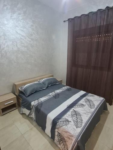 a bedroom with a bed and a window with curtains at Charmant appartement pour votre séjour a Bouskoura a Casablanca in Bouskoura