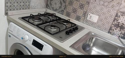 a stove top oven in a kitchen next to a sink at EnjoyCasa Tra Sole Mare e L'Etna in Adrano