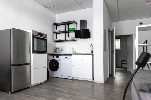 a kitchen with white cabinets and a washer and dryer at Apartment mit vier Einzelboxspringbetten - Netflix in Goch