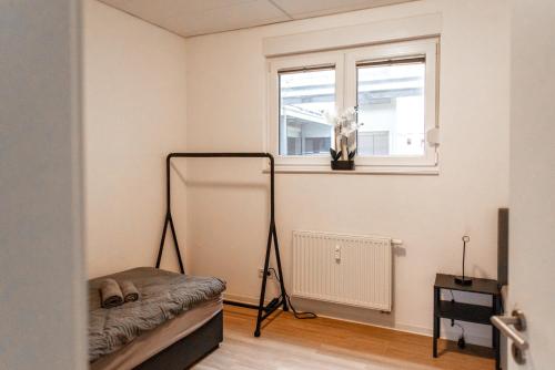 a room with a tripod in a room with a window at Apartment mit vier Einzelboxspringbetten - Netflix in Goch