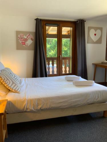 a bedroom with a large bed with a window at Hôtel-Bar-Restaurant Les Dômes de Miage in Saint-Gervais-les-Bains