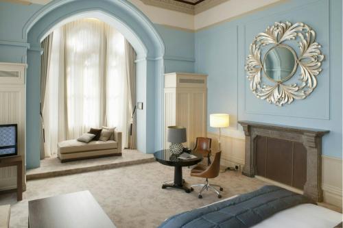 a living room with blue walls and a fireplace at St Pancras London, Autograph Collection in London