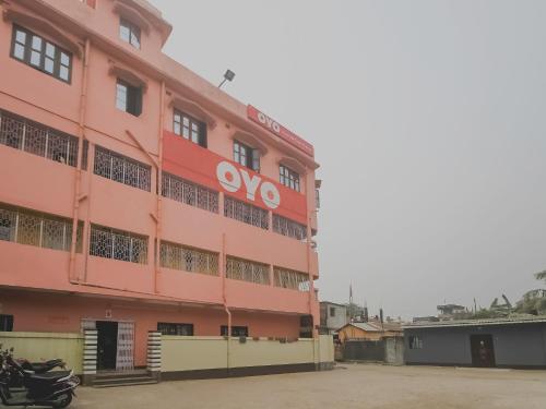 a pink building with an ovo sign on it at Hotel O Krishna Guest House Siliguri Railway Station in Panchanai