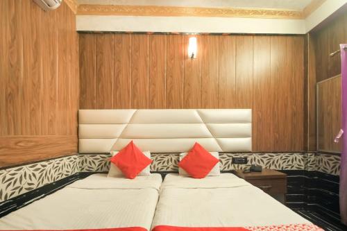 a bedroom with two beds with red pillows at Hotel O Krishna Guest House Siliguri Railway Station in Panchanai