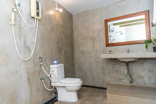 a bathroom with a shower and a toilet and a sink at Eco Hotel Black & White - Anuradhapura in Mihintale