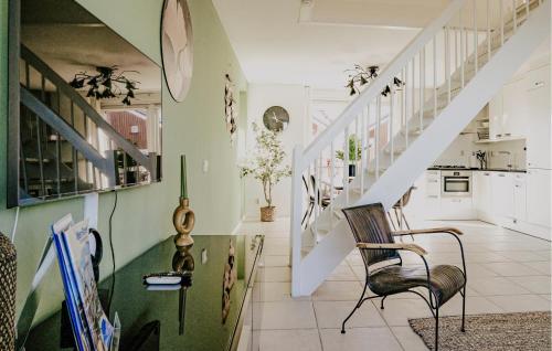 ein Wohnzimmer mit einer Treppe und einem Stuhl in der Unterkunft Oostergeest Beneden 2 Slaapk in Uitgeest