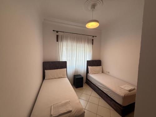 twee bedden in een kleine kamer met een raam bij Residence Anuar T in Tetouan