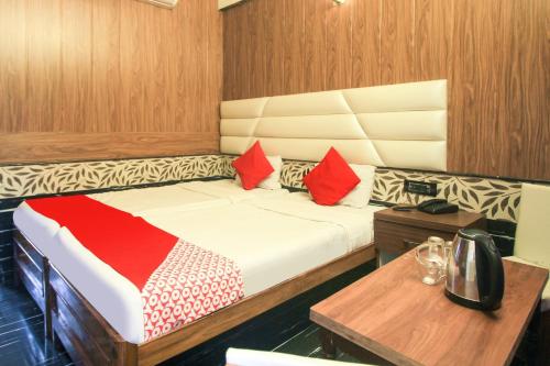 a bedroom with a bed with red pillows on it at Hotel O Krishna Guest House Siliguri Railway Station in Panchanai