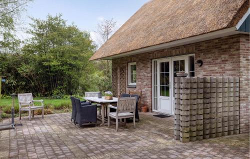 a patio with a table and chairs in front of a building at 3 Bedroom Cozy Home In Paasloo in Paasloo