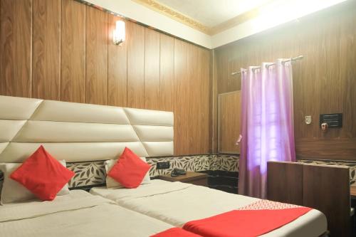 a bedroom with two beds with red pillows at Hotel O Krishna Guest House Siliguri Railway Station in Panchanai