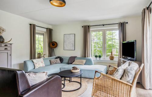 a living room with a blue couch and chairs at 3 Bedroom Cozy Home In Paasloo in Paasloo