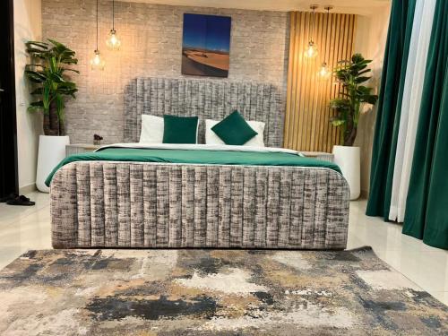 a bedroom with a large bed with green sheets at Gold crest serviced apartments DHA phase four Lahore in Dargai