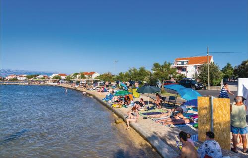 a group of people on a beach near the water at Apartment Maslenica in Jasenice