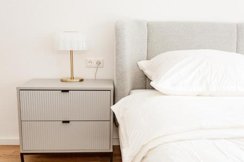 a bed with a night stand with a lamp on it at Ferienhaus Arina in Bad Bertrich