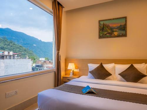 a bedroom with a bed and a large window at Moustache Rishikesh Luxuria in Rishīkesh