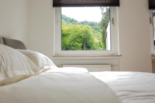 a bedroom with a white bed and a window at Ferienhaus Arina in Bad Bertrich