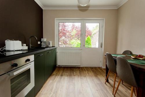 a kitchen with a table and a window at Ferienhaus Arina in Bad Bertrich
