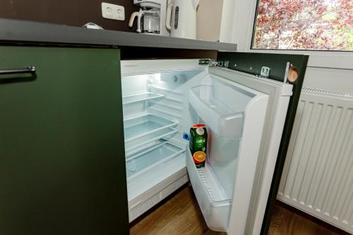an empty refrigerator with its door open in a kitchen at Ferienhaus Arina in Bad Bertrich