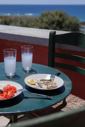 a table with two plates of food and two glasses of milk at Dialiskari Villas in Marathopolis