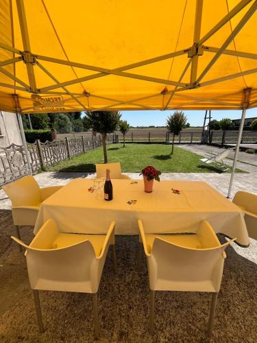 a table and chairs under a yellow umbrella at Il Tulipano - Villa con giardino in Bionde di Visegna